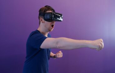 man punching in the air while in vr goggles